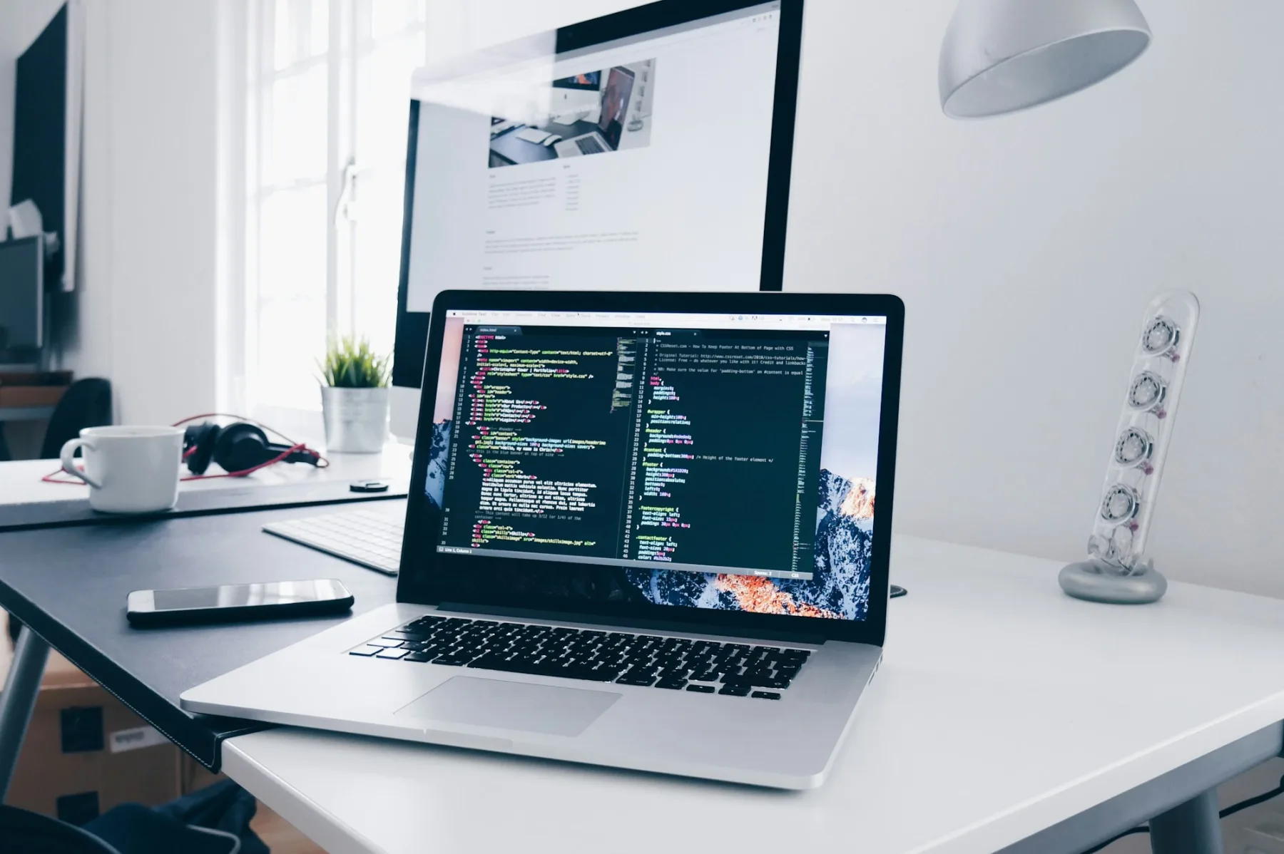 Developer typing code on a MacBook — web development workflow.